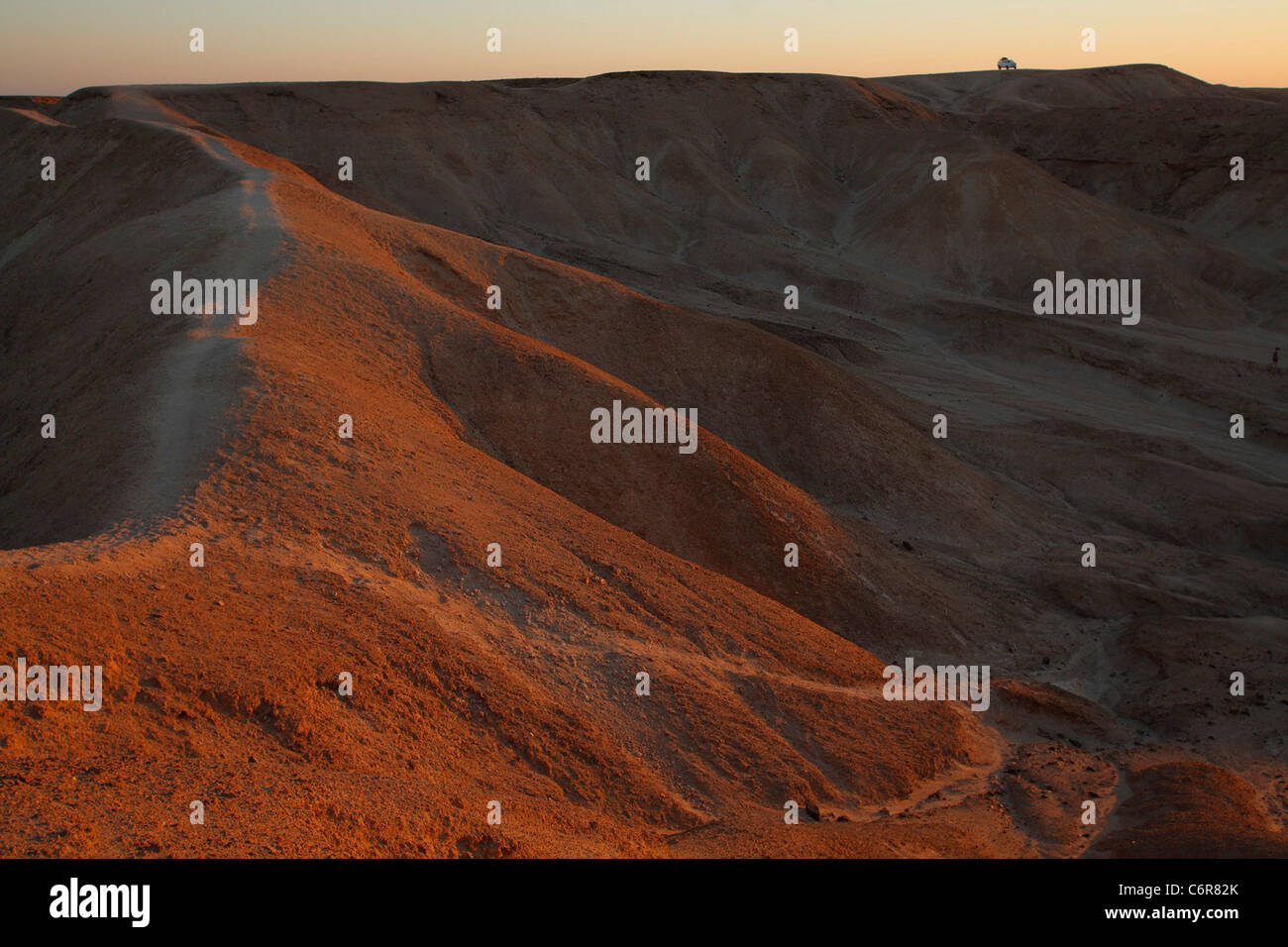 Paysage désertique avec véhicule isolé sur une crête dans la distance Banque D'Images