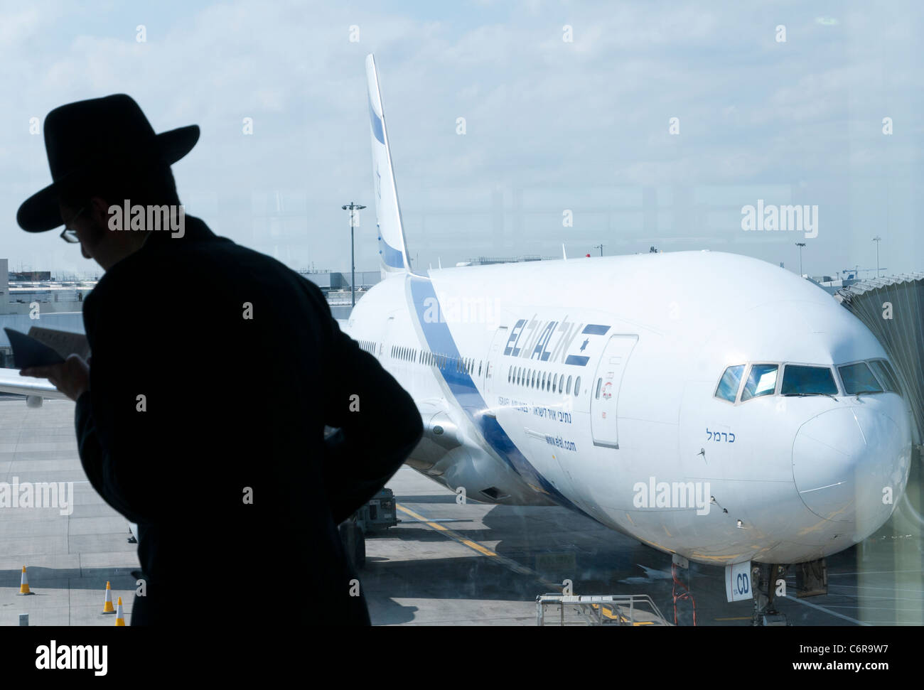 Juif orthodoxe priant avec El Al en avion Bkgd. L'aéroport de Heathrow. Londres Banque D'Images