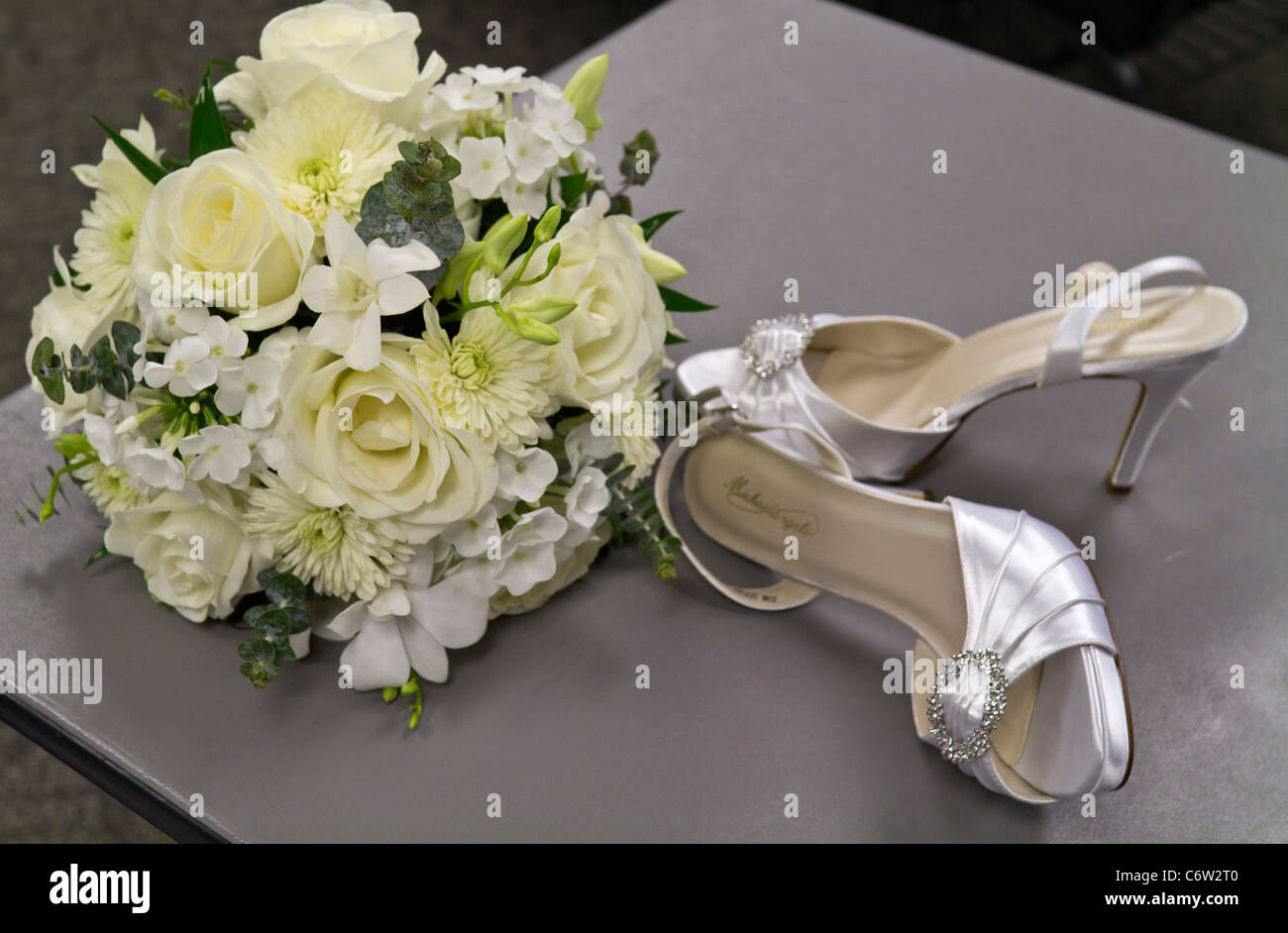 Les chaussures de mariage de la mariée et un beau bouquet de mariage de roses blanches au-dessus du haut closeup personne horizontal aux États-Unis haute résolution Banque D'Images