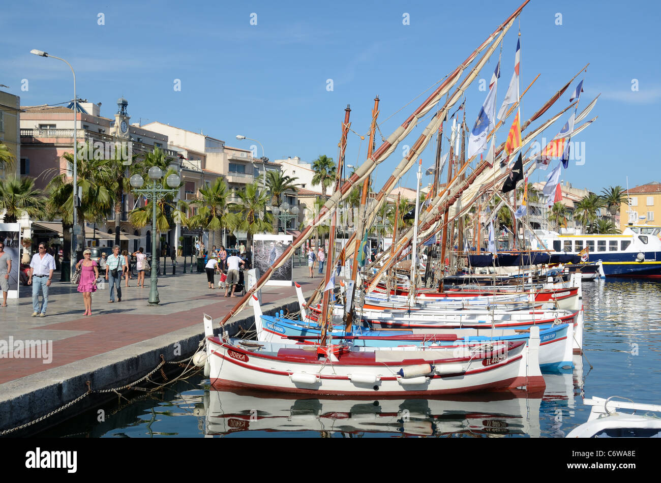 Port de plaisance, port, bateaux à voile en bois colorés ou bateaux de pêche peints et touristes sur le front de mer ou le bord de mer Sanary-sur-Mer sud de la France Banque D'Images