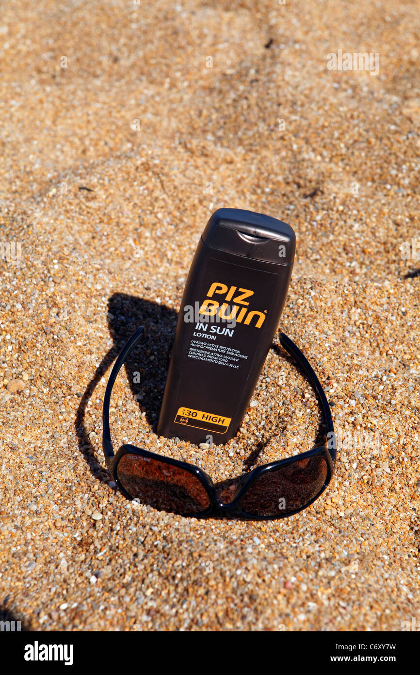 Crème solaire et lunettes de soleil sur la plage Banque D'Images
