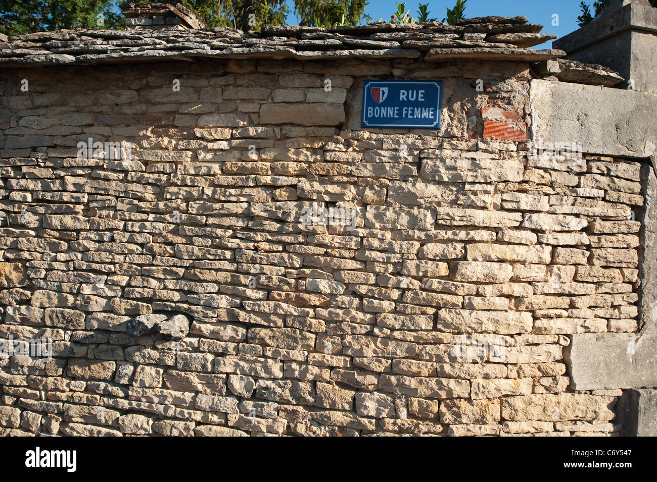 Mur de pierre avec l'émail plaque de rue rue Bonne Femme dans la production du vin français, village de Monthelie en Bourgogne. Banque D'Images