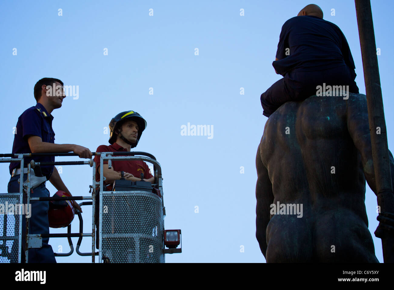 Elle : Bologne, un réfugié marocain a grimpé sur la statue de Neptune dans la Piazza Maggiore, protestant, pour le permis de résidence. Banque D'Images