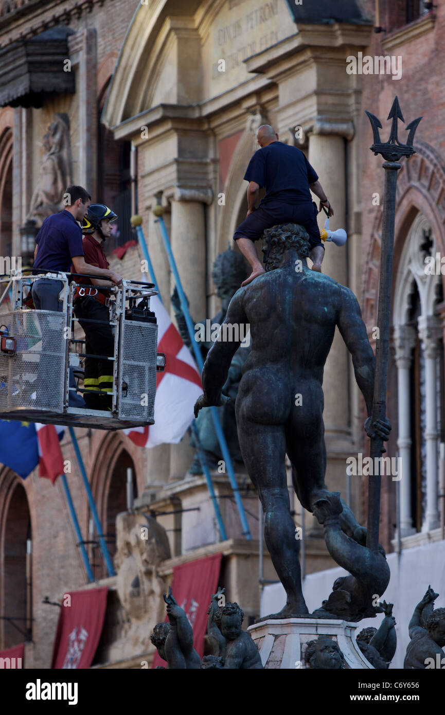 Elle : Bologne, un réfugié marocain a grimpé sur la statue de Neptune dans la Piazza Maggiore, protestant, pour le permis de résidence. Banque D'Images