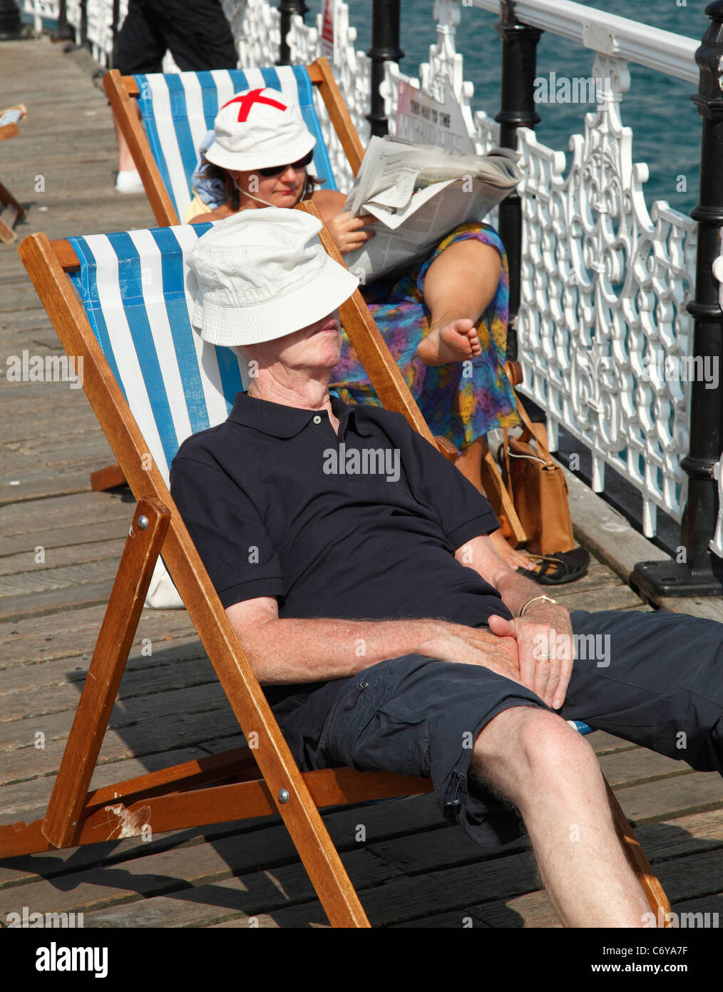 Les vacanciers en vous relaxant dans des chaises longues sur la jetée de Brighton, Brighton, Angleterre, Royaume-Uni Banque D'Images