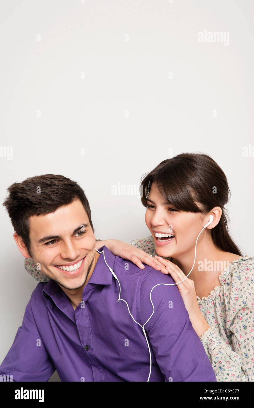 Smiling couple listening to headphones Banque D'Images