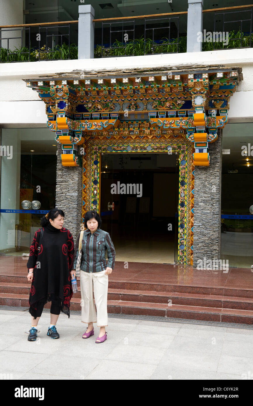 Les touristes & porte / entrée avant de l'visitor centre / centre de la réserve naturelle de la vallée de Jiuzhaigou, Sichuan, Chine. Banque D'Images
