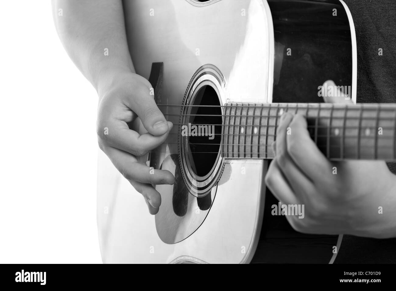 Un gros plan du mans et les mains qui grattent la guitare acoustique électrique isolé sur un fond blanc. Banque D'Images
