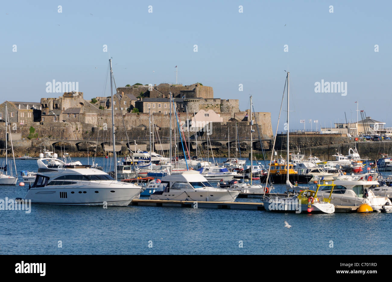 Bateaux amarrés au port de St Peter Port. Dans l'arrière-plan est Castle Cornet et le brise-lames qui joint à la terre ferme Banque D'Images