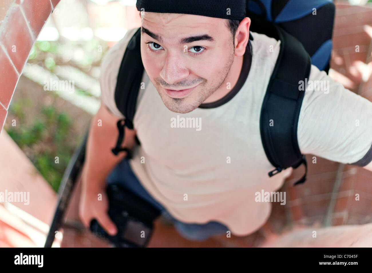 Portrait d'un jeune voyageur avec votre appareil photo reflex numérique à la main et sac à dos. L'italien à la brunette guy dans son 20s. Banque D'Images