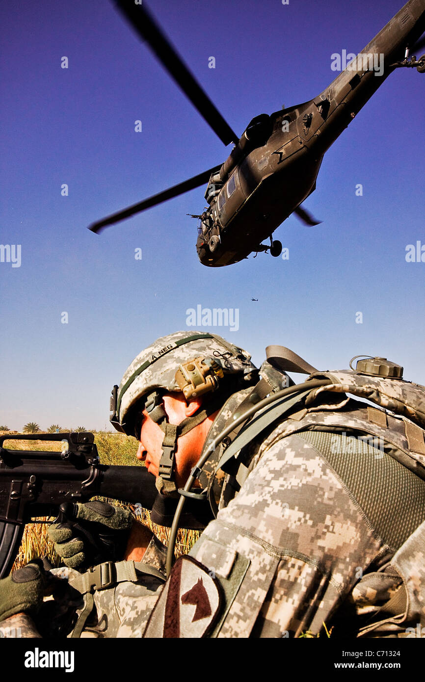 Après avoir agressé l'air dans une zone d'atterrissage, la CPS. Khalid Hermez, de Detroit, tire sur la sécurité comme un UH-60 Black Hawk quitte la zone d'atterrissage. Les soldats de la 1st Air Cavalry Brigade et la 34e Brigade de l'armée irakienne a effectué une mission d'assaut aérien mixte et de patrouille pour vérifier les conditions de vie d'un petit village au nord d'ici, le 12 novembre. Banque D'Images