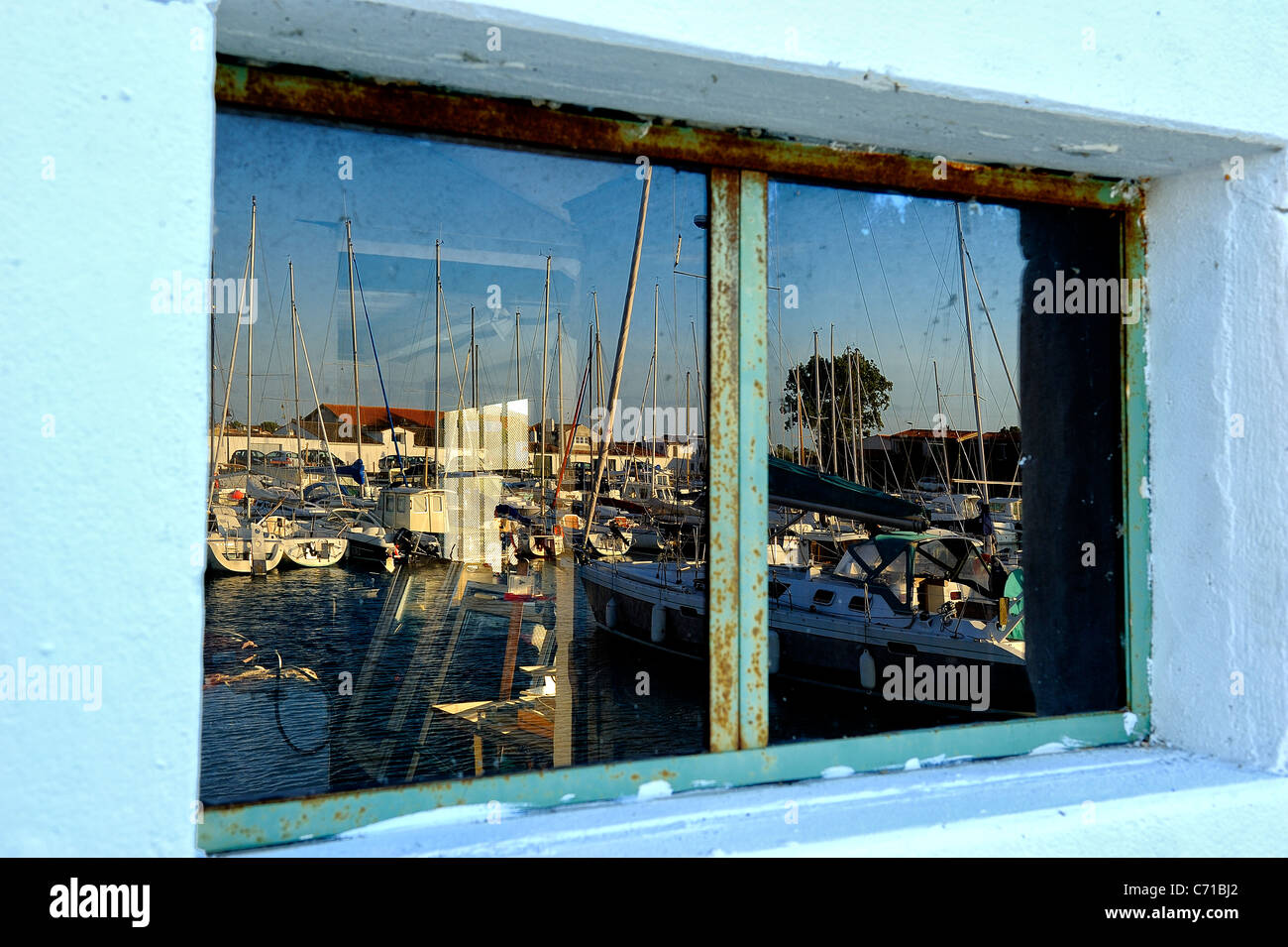 Réflexions dans une fenêtre de navigation des bateaux amarrés dans le port d'Ars en Ré, Charente Maritime nrise ministère, ouest de la France Banque D'Images