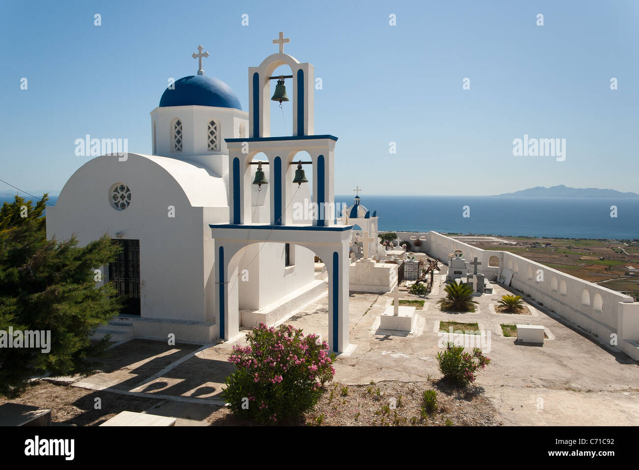 L'église grecque blanc dôme bleu et clocher à Exo Gonia, Santorini, Grèce avec l'île d''Anafi à distance Banque D'Images