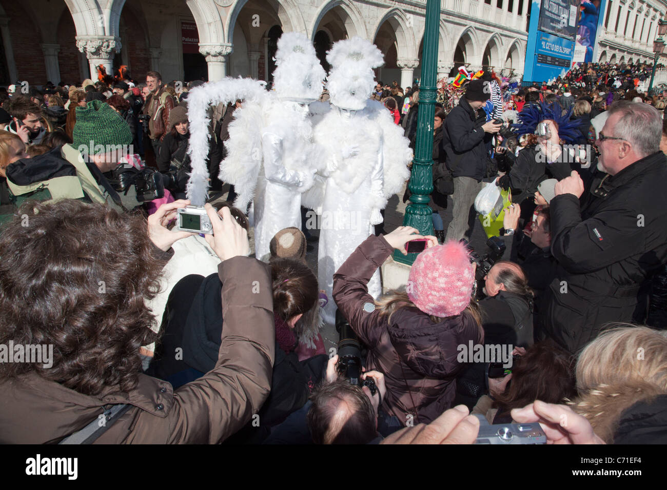 Les foules se rassemblent autour de deux personnes habillées en costume au cours de Carnivale 2011 à Venise Italie Banque D'Images