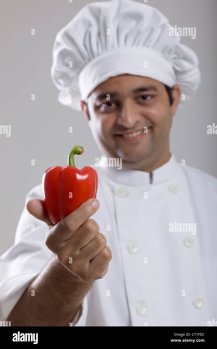 Chef holding a red bell pepper Banque D'Images