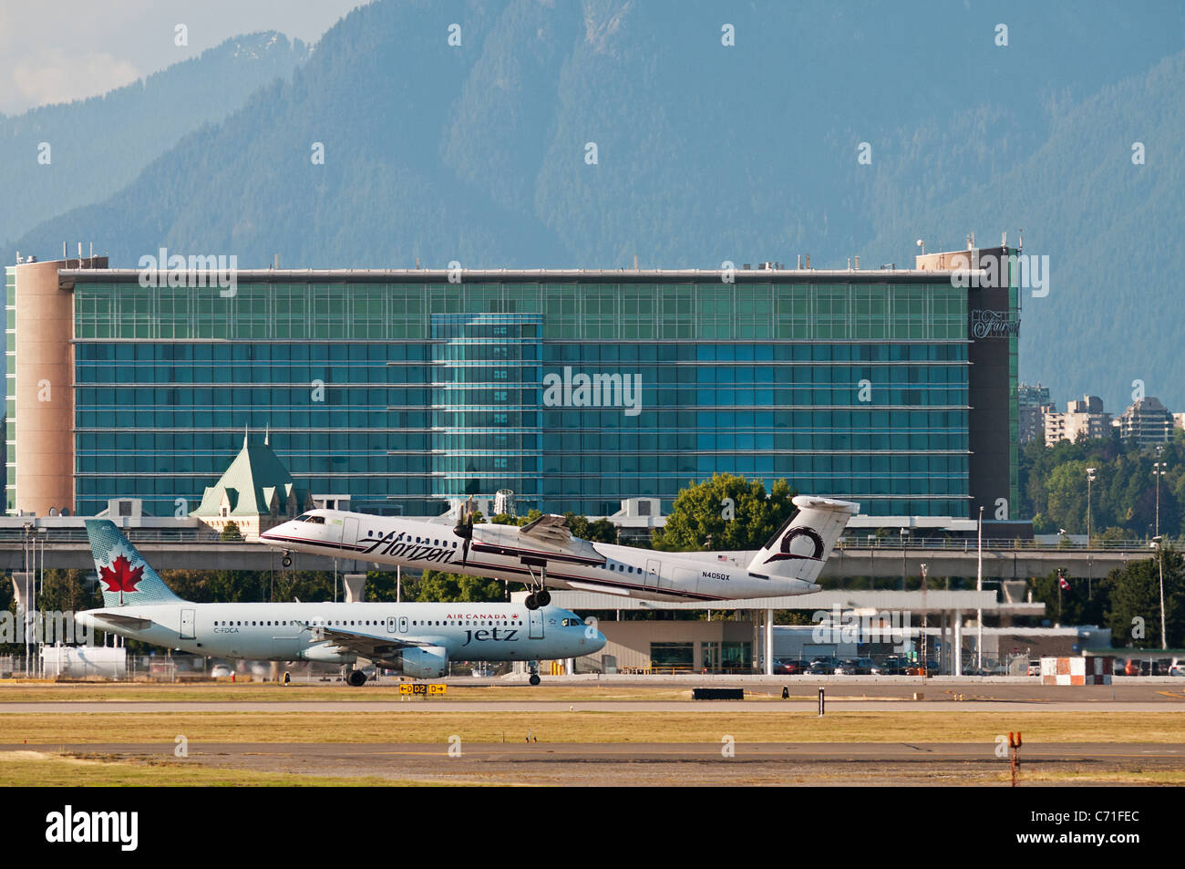 Avions de ligne : Horizon Air Bombardier Dash 8 et d'un Airbus d'Air Canada Jetz Airbus A320 à l'Aéroport International de Vancouver, Canada. Banque D'Images