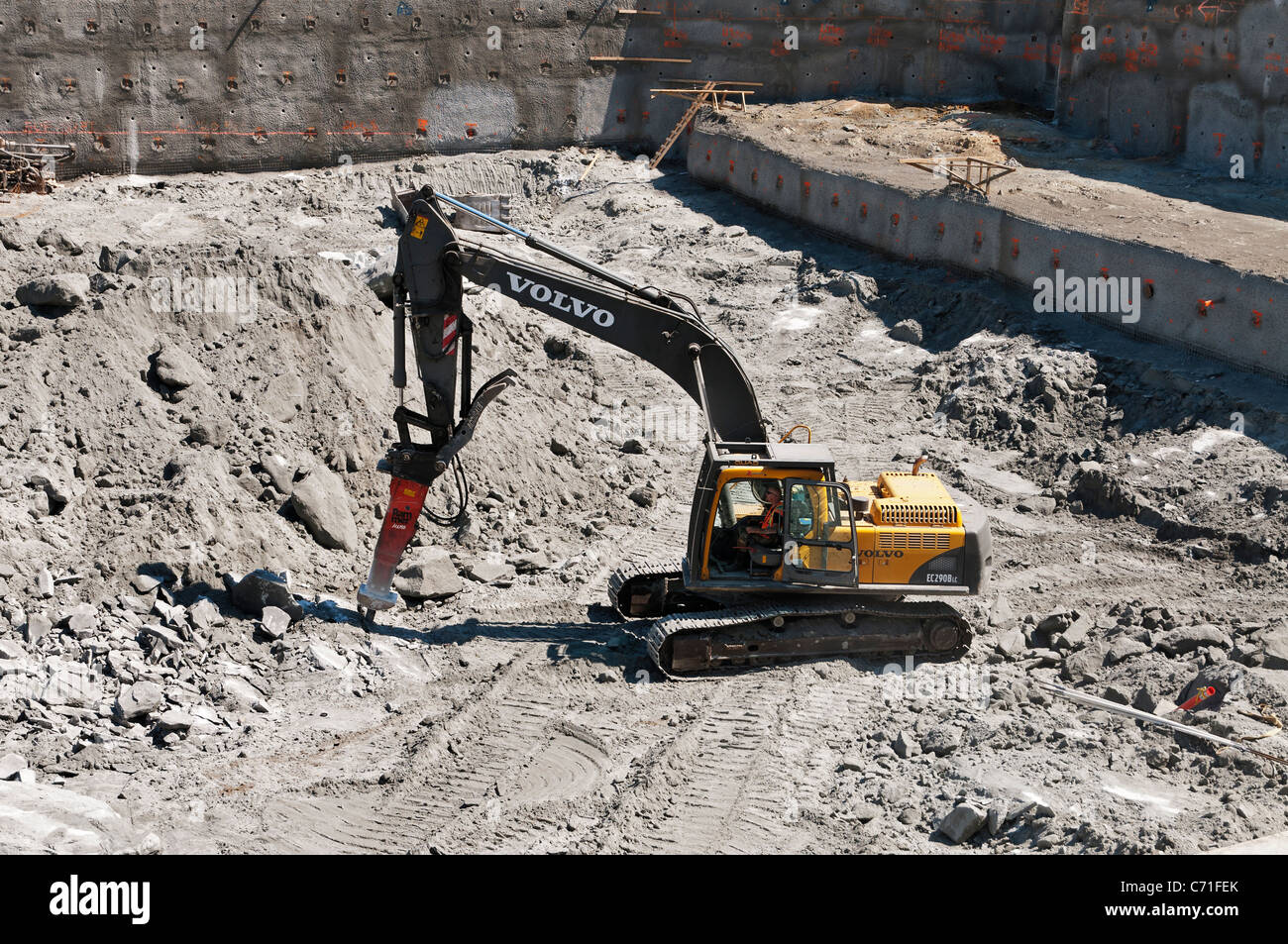 Une Volvo EC290B LC pelle avec un marteau hydraulique attaché casse vers le haut rocher sur un chantier de construction à Vancouver. Banque D'Images