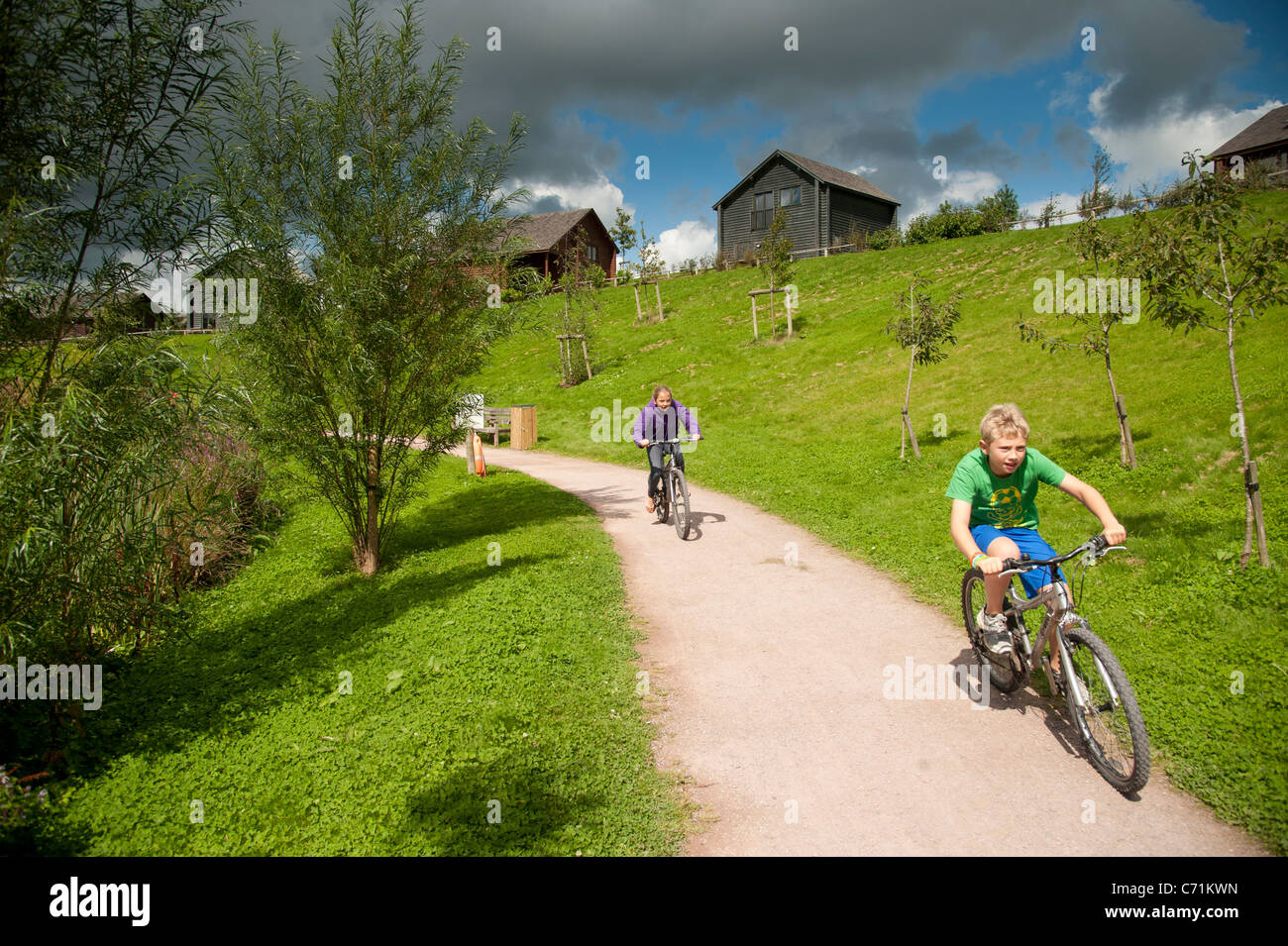 Les enfants à vélo au Parc National de pierre de village de vacances centre de vacances, l'ouest du pays de Galles pembrokeshire uk Banque D'Images