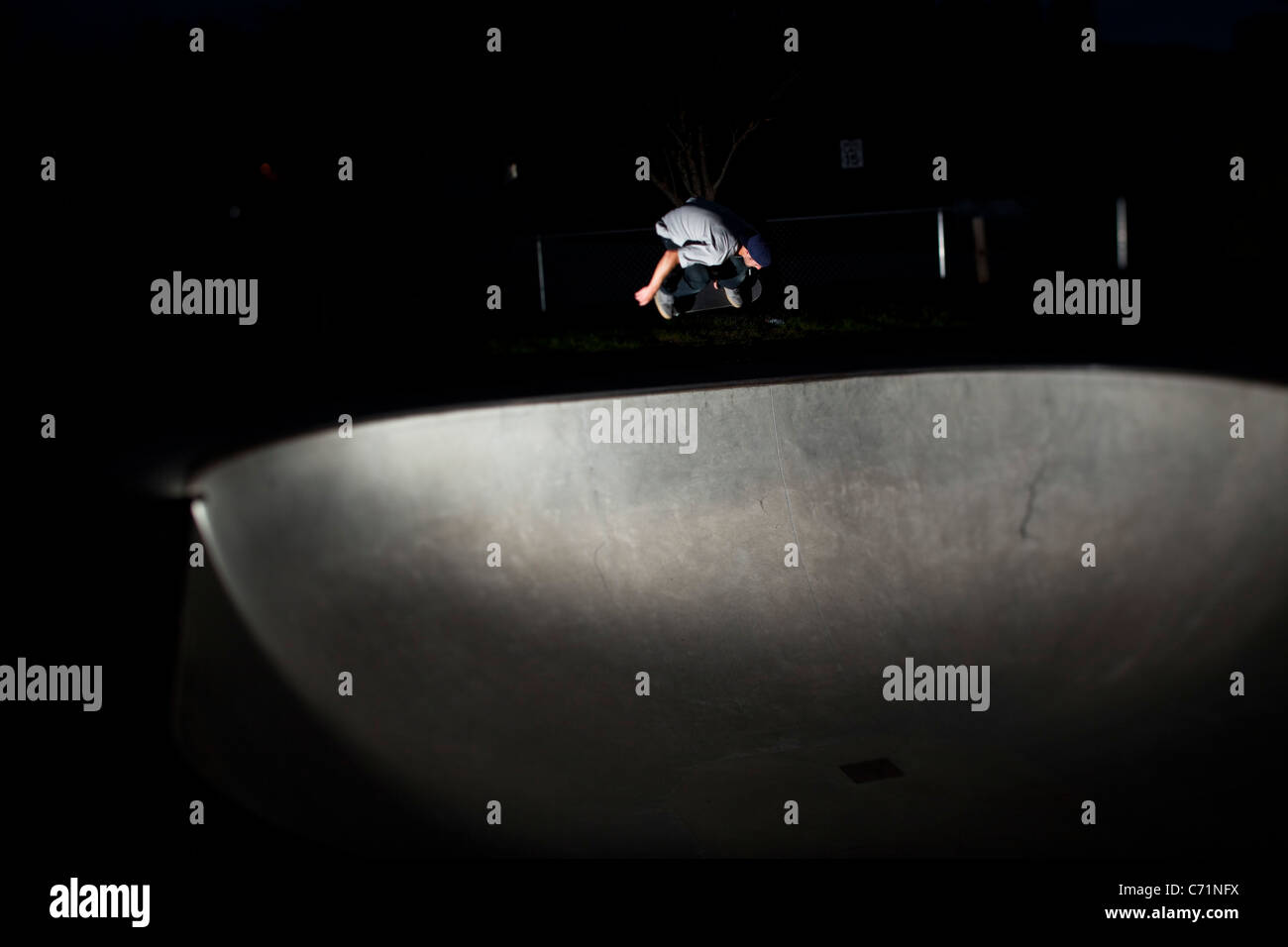 Un heureux homme athlétique skateboards dans la nuit dans l'Idaho. Banque D'Images