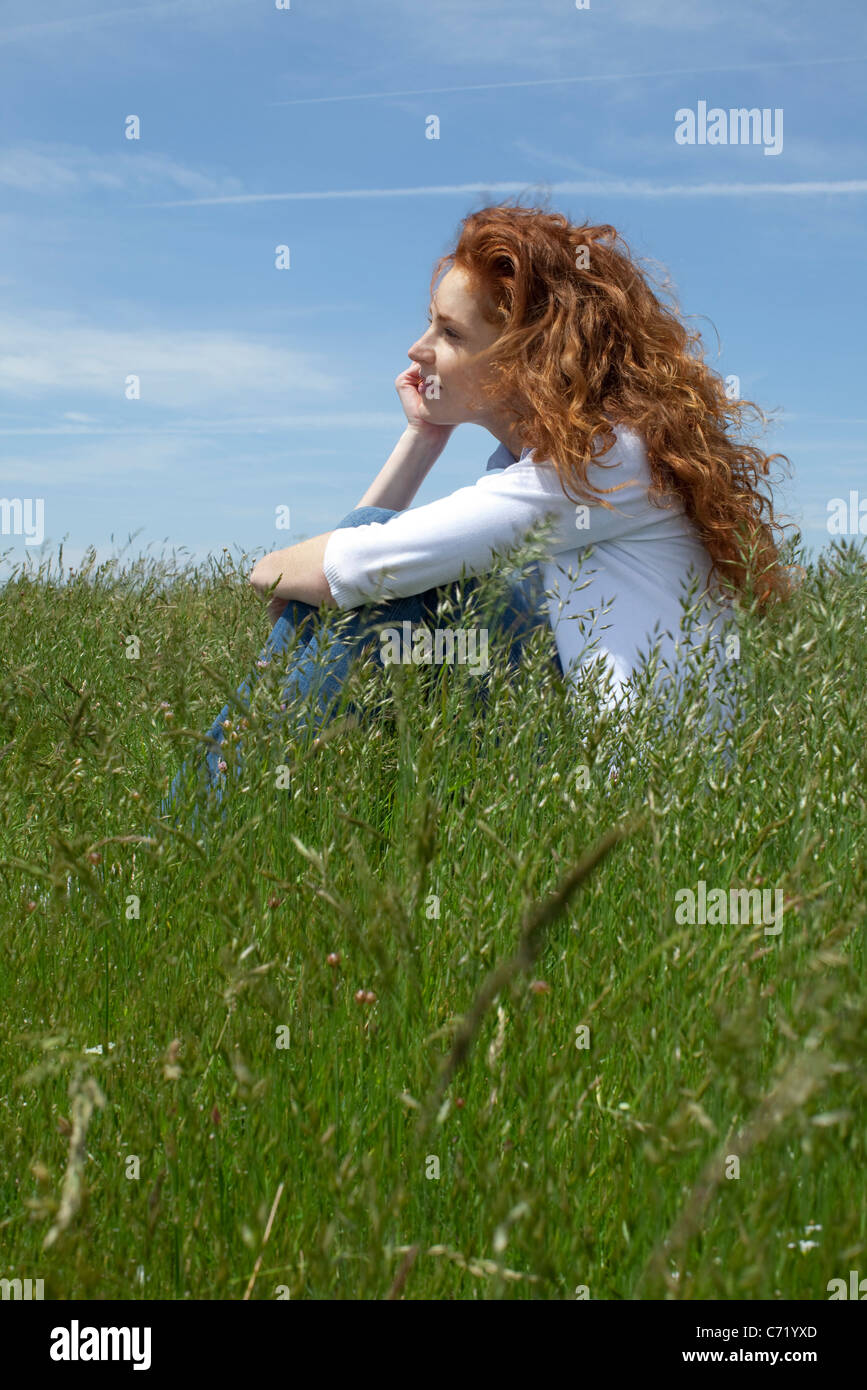 Woman daydreaming in meadow Banque D'Images