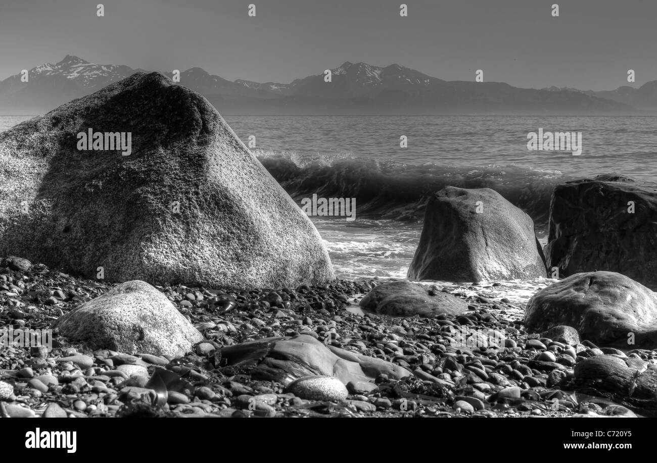 De gros rochers et vagues à Diamond Beach sur la côte de l'Alaska en noir et blanc. Banque D'Images