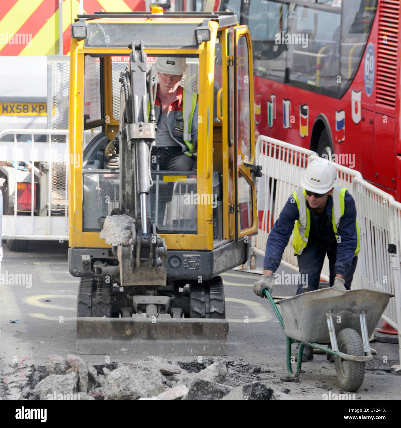 Travailleurs de la visualisation aérienne et minipelle hydraulique travaillant sur route dans la voie de bus à côté de la circulation bourrage de rouge à deux étages Bus Regent Street West End Londres Royaume-Uni Banque D'Images