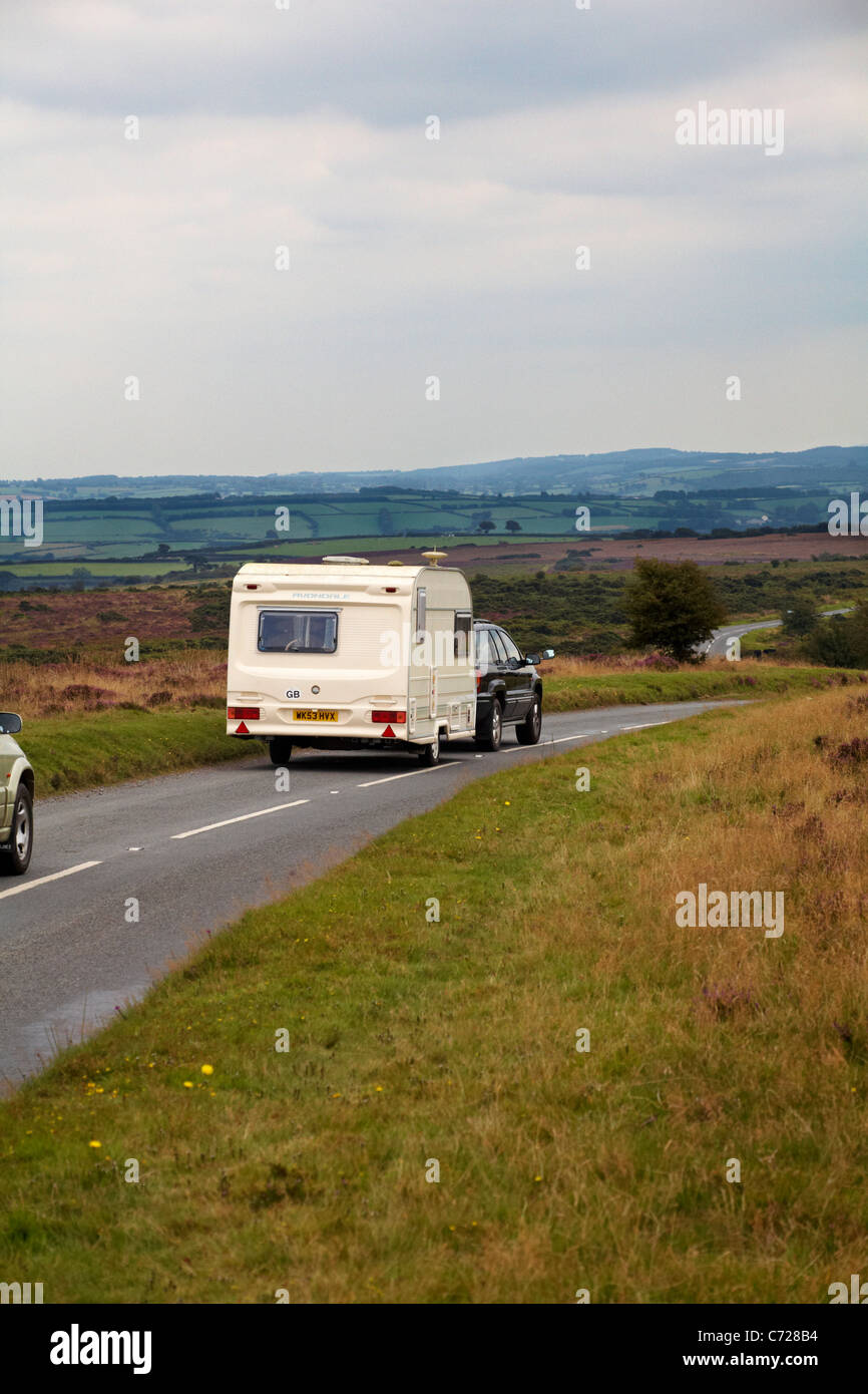 Caravane de remorquage en voiture traversant le parc national d'Exmoor, Devon UK en août - caravane de tourisme Caravaning Banque D'Images