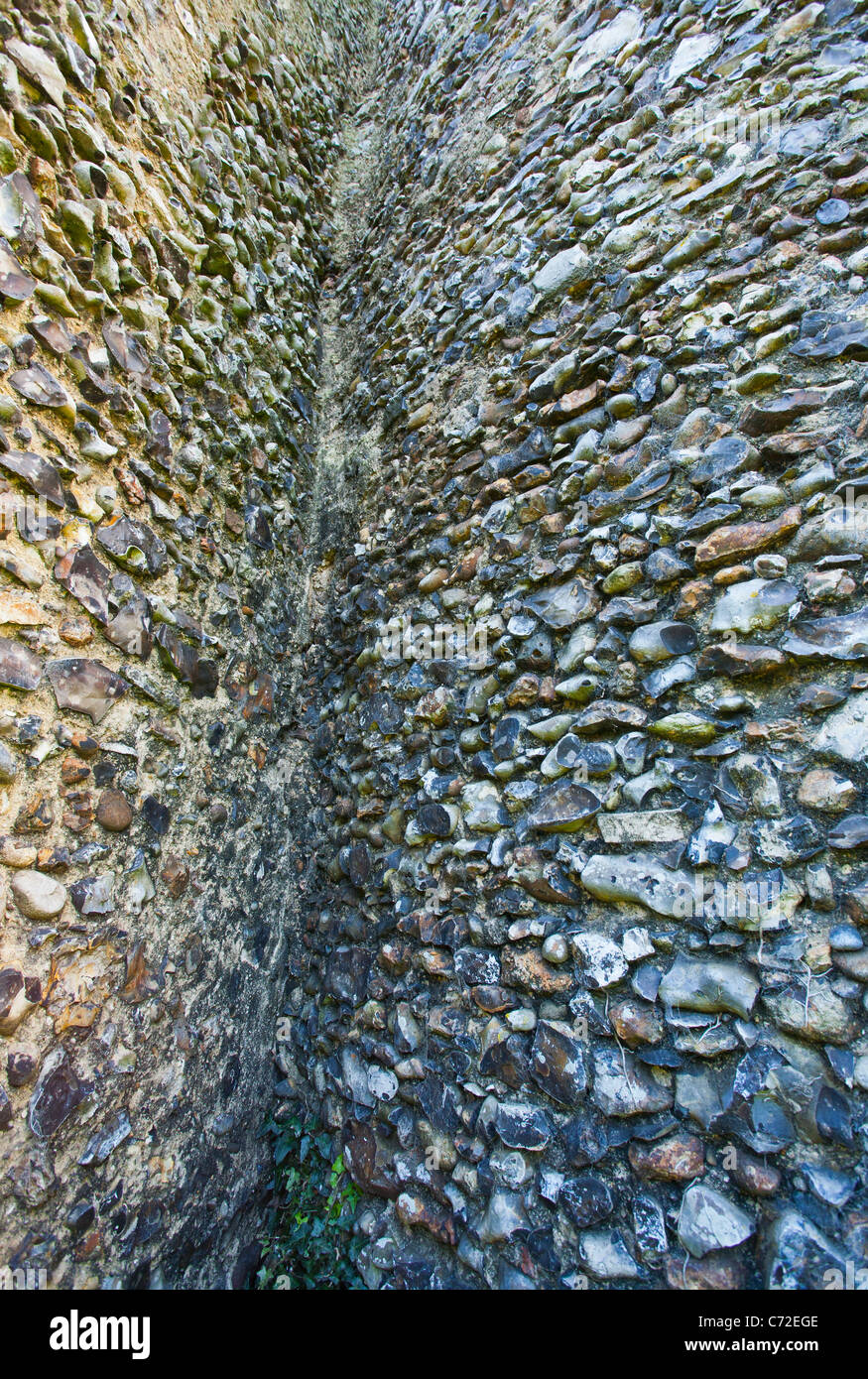 Le silex mur de l'église en ruine de St Mary à Kirby Bedon au point où elle rejoint la tour. Banque D'Images