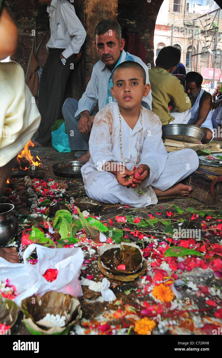 Prêtre pèlerin bénédiction garçon à Har Ki Pairi ghat par le Gange. Banque D'Images