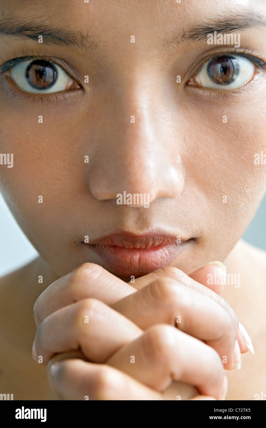 Closeup portrait of a young woman praying Banque D'Images