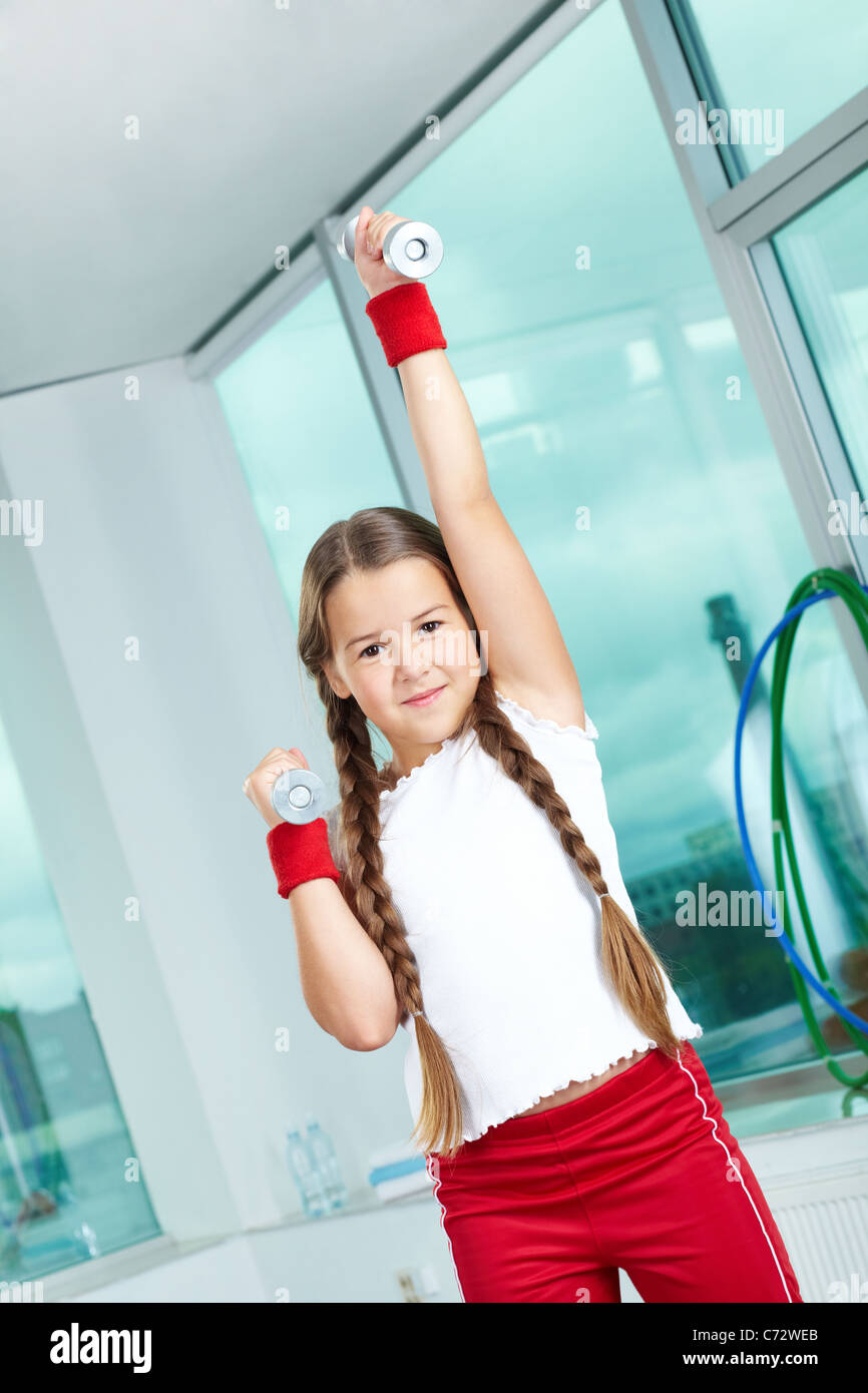 Portrait de jeune fille en bonne santé pratiquant l'exercice physique dans la salle de sport Banque D'Images