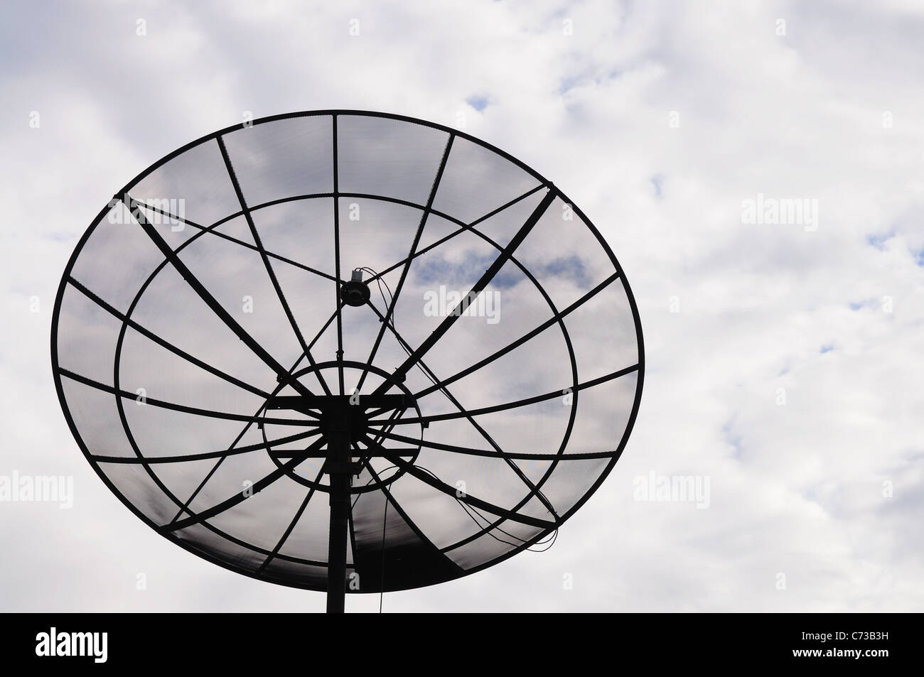 Antenne satellite dans ciel nuageux Banque D'Images