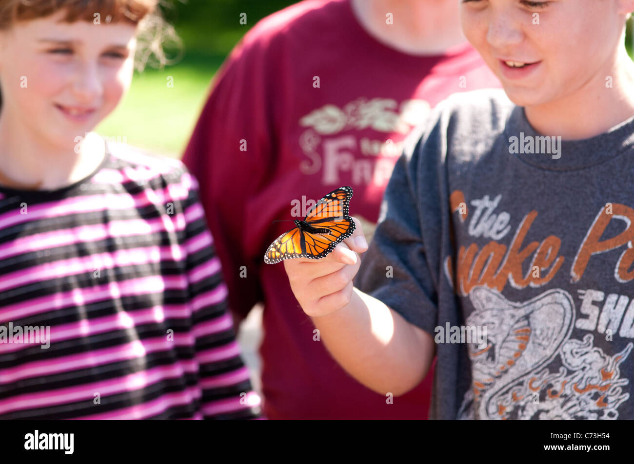 Les enfants de l'école libération tagged papillon monarque. Banque D'Images