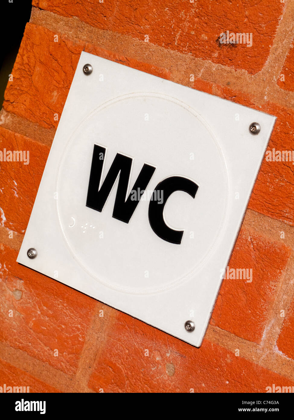 Plastique tactile affiche à l'extérieur des toilettes publiques avec texte braille pour les utilisateurs malvoyants Banque D'Images