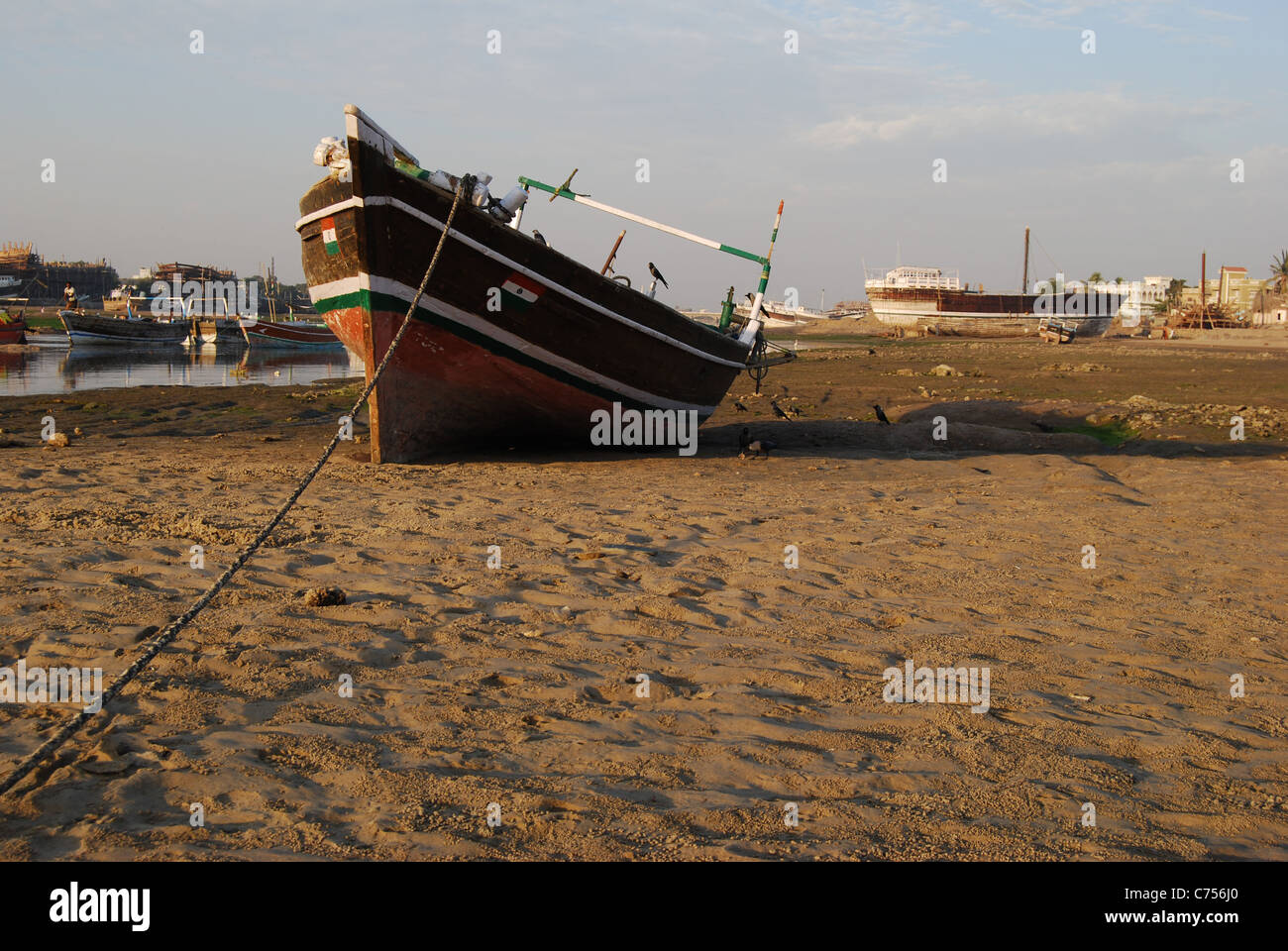Un bateau est amarré sur la rive. Dans l'arrière-plan, un autre bateau est en réparation (Inde) Banque D'Images