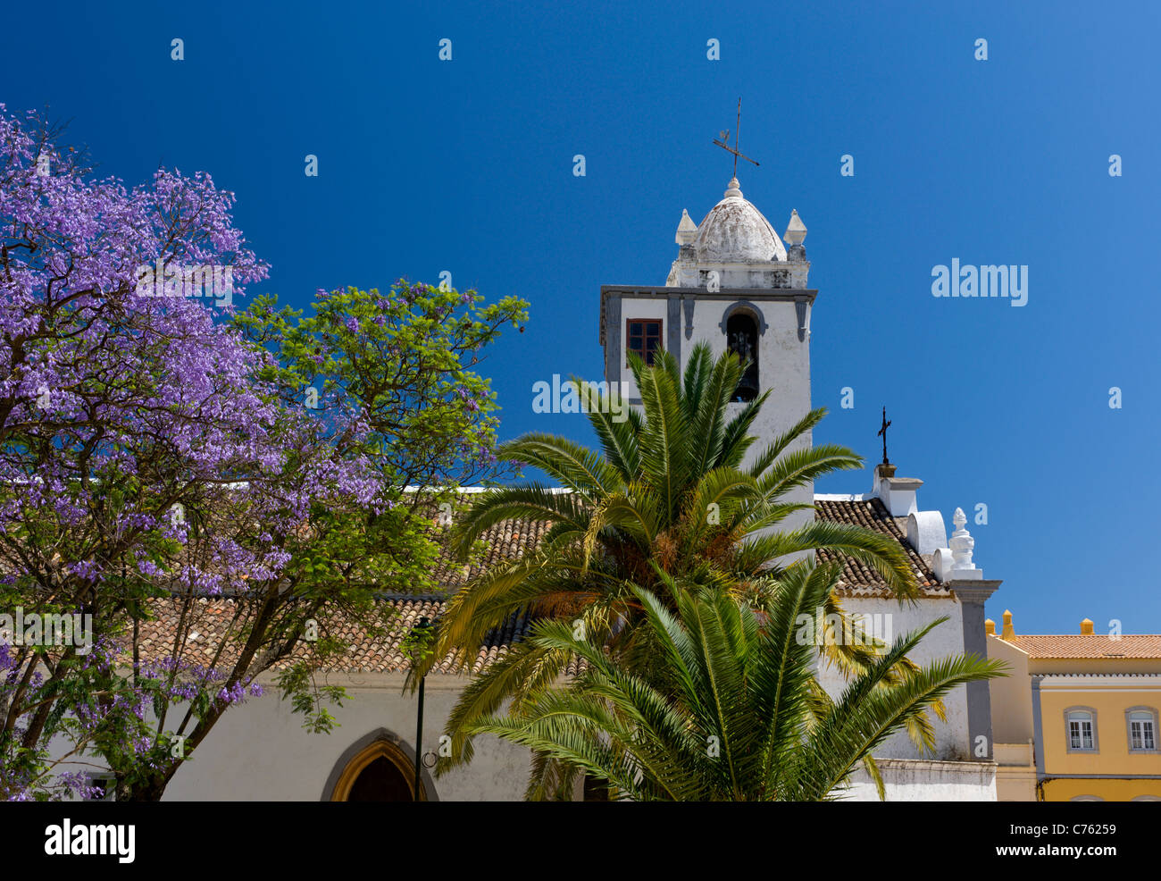 Le Portugal, l'Algarve, Ferragudo village church et jacaranda tree in flower Banque D'Images