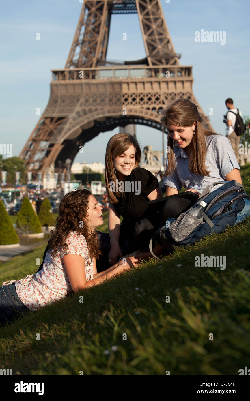 France, Paris, trois jeunes femmes sur la pelouse en face de la Tour Eiffel Banque D'Images