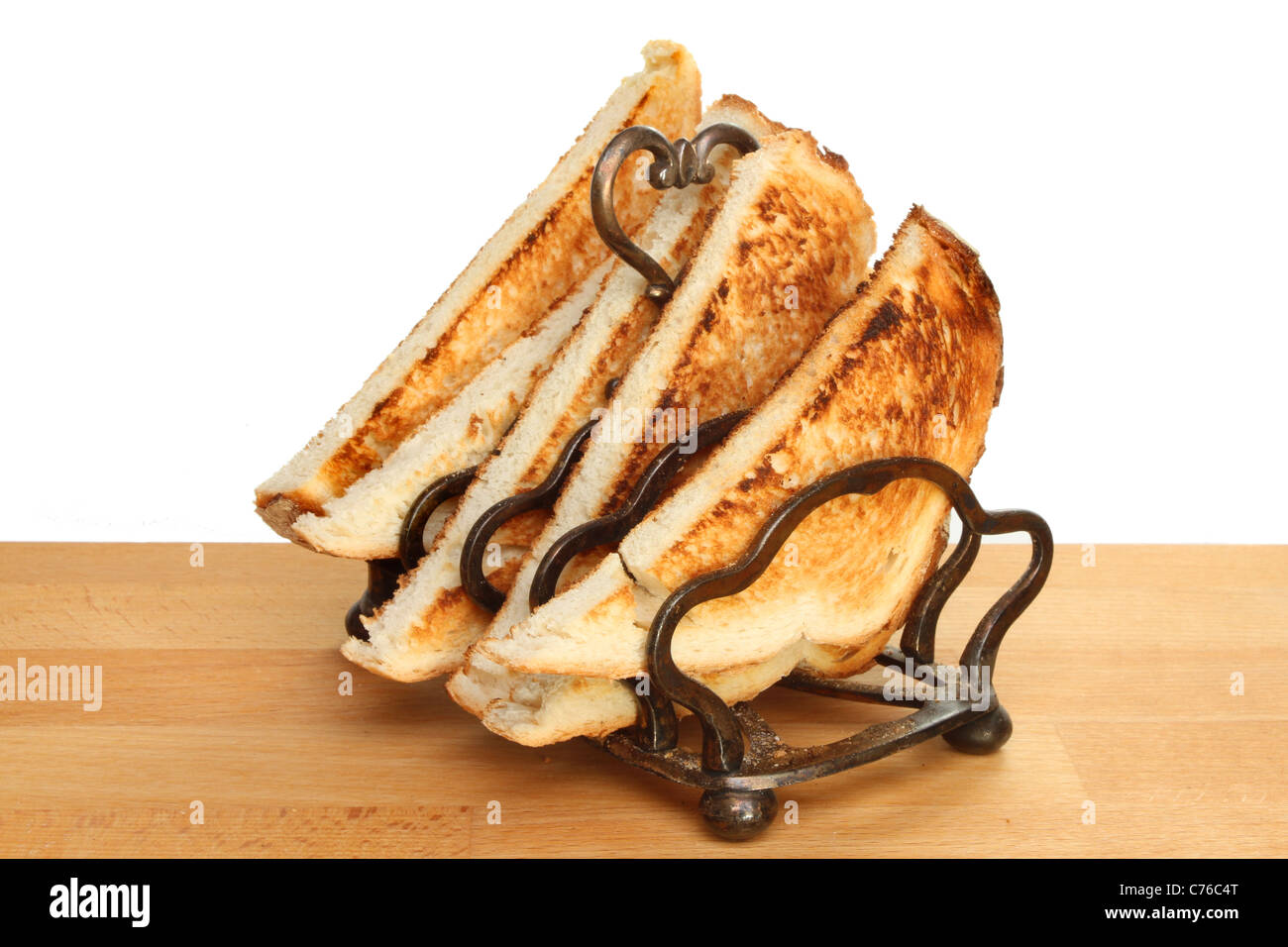 Toast dans un rack sur un plan de travail en bois sur un fond blanc. Banque D'Images