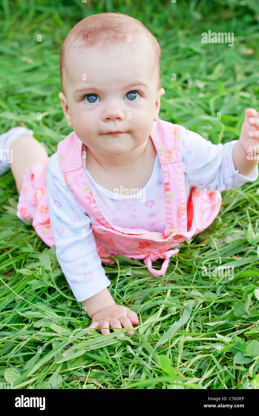 Happy baby girl lying on grass Banque D'Images