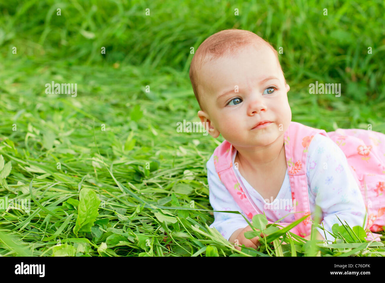 Sweet baby girl lying on grass Banque D'Images