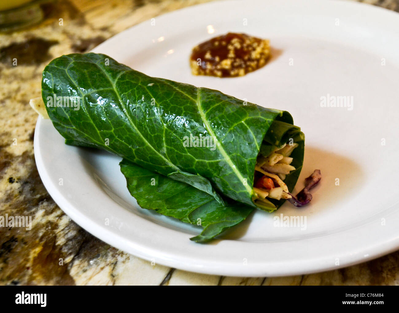 Collard cru rouler sur plaque blanche. Banque D'Images