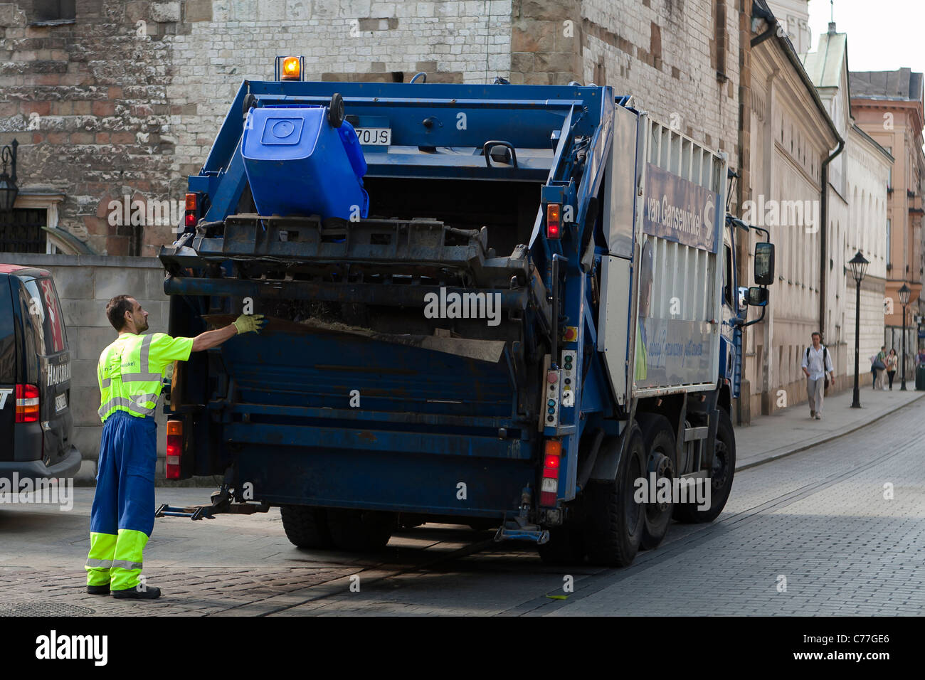 Pendant les travaux en travailleur de nettoyage avec camion de collecte des ordures de la rue. Cracovie, Pologne. Banque D'Images