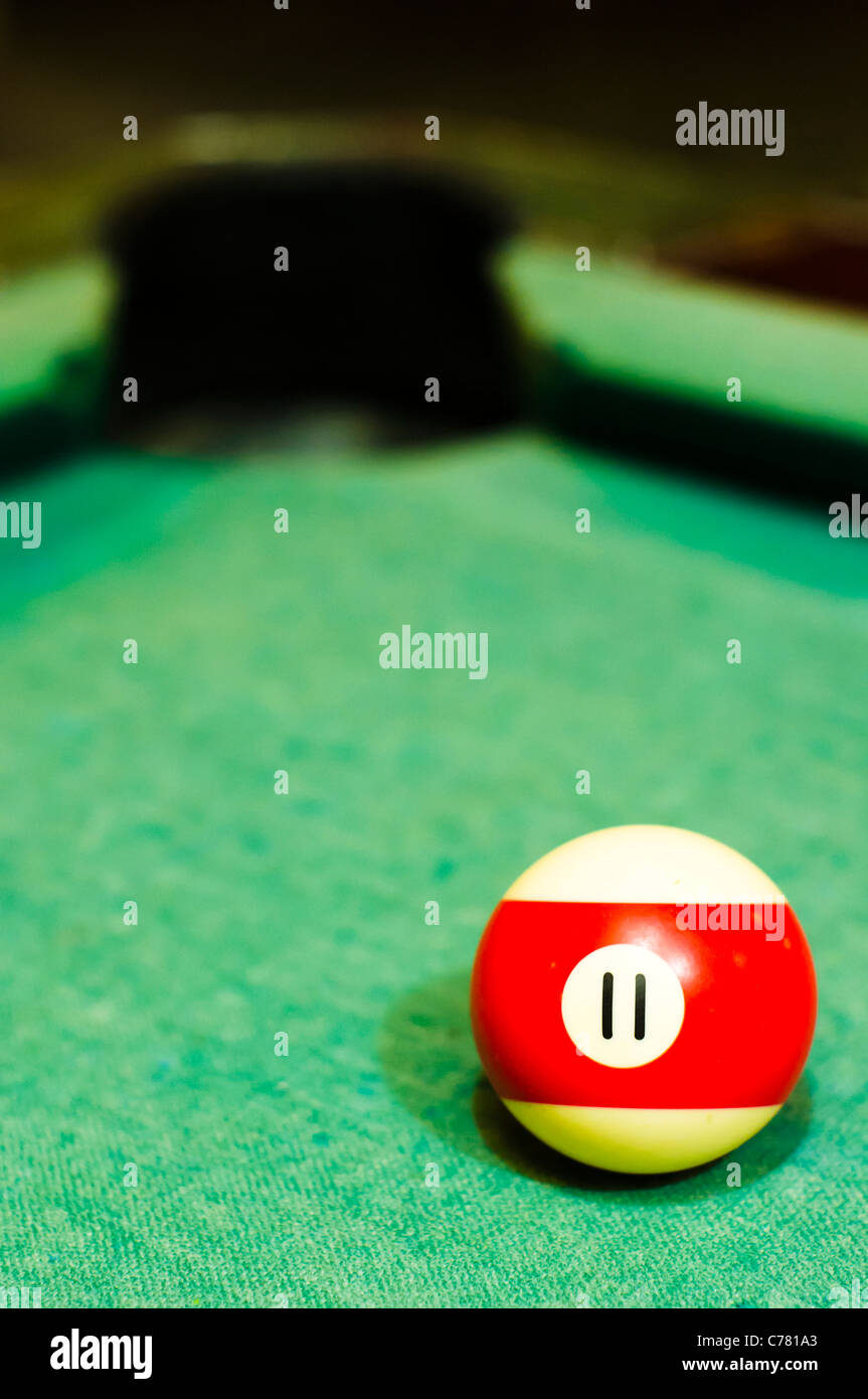 Un gros plan de boule de billard numéro 11, à rayures rouges, pour l'utilisation conceptuelle. Banque D'Images
