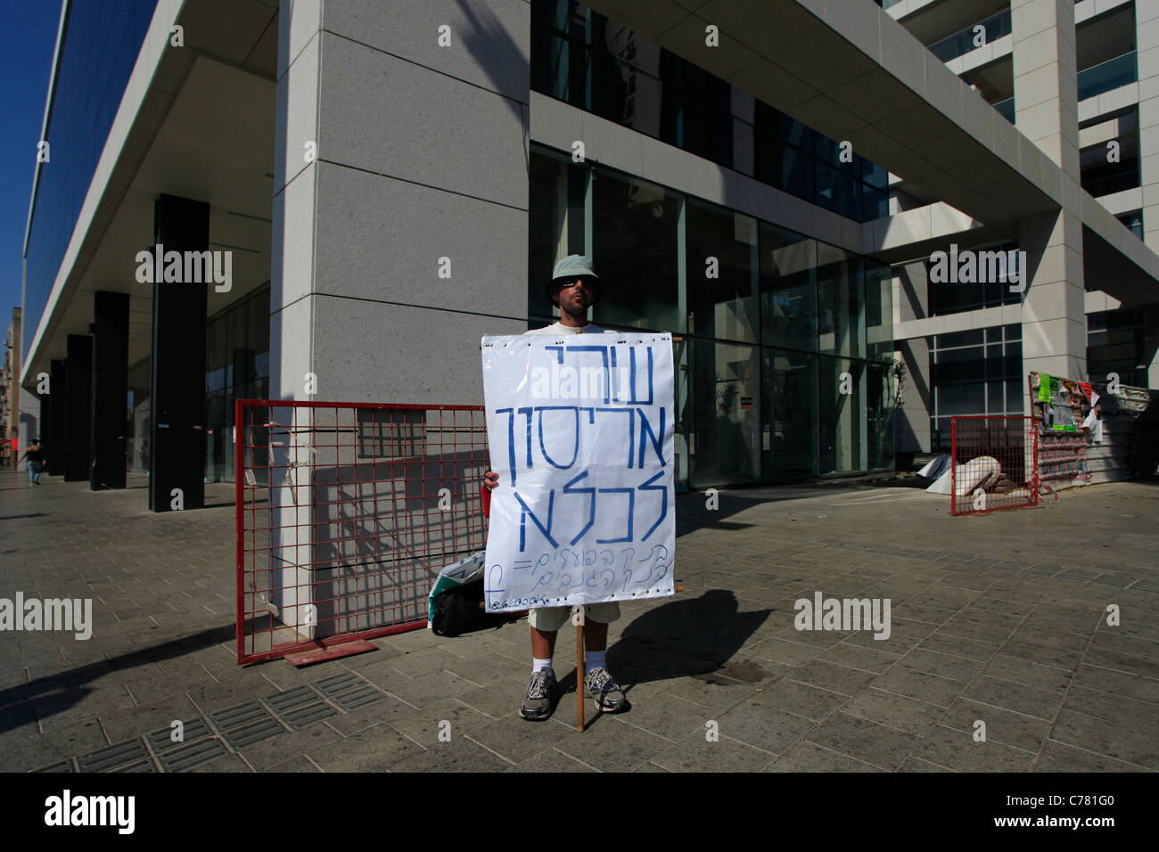 Un manifestant est titulaire d'un signe de carton en hébreu qui dit 'Shari Arison en prison' en face de la Banque Hapoalim contrôlée par Arison Holdings, qui est administré par Shari Arison à Tel Aviv, Israël. La justice sociale protester également nommé les tentes contestation ont été une série de manifestations en Israël à compter de juillet 2011 impliquant des centaines de milliers de manifestants à partir d'une variété de facteurs socio-économiques s'opposant à la poursuite de l'augmentation du coût de la vie particulièrement dans le secteur du logement. Banque D'Images