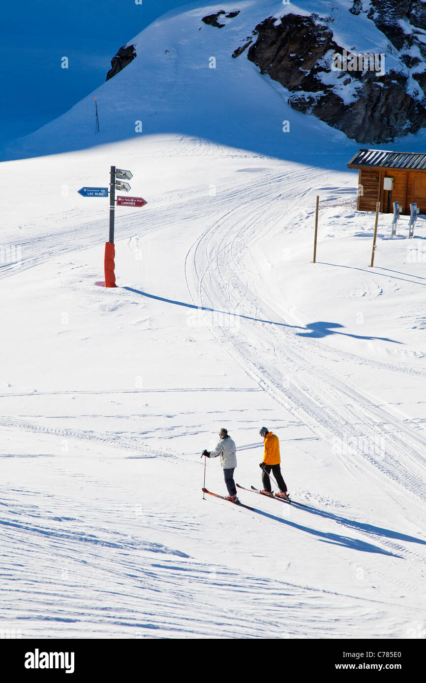 Skieurs et signpost, Courchevel 1850, France. Banque D'Images