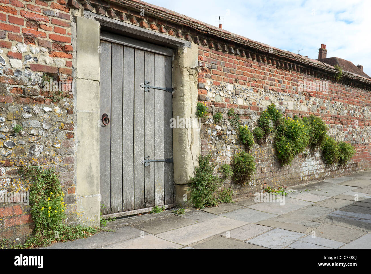Vieux mur de briques et silex avec porte en bois Banque D'Images