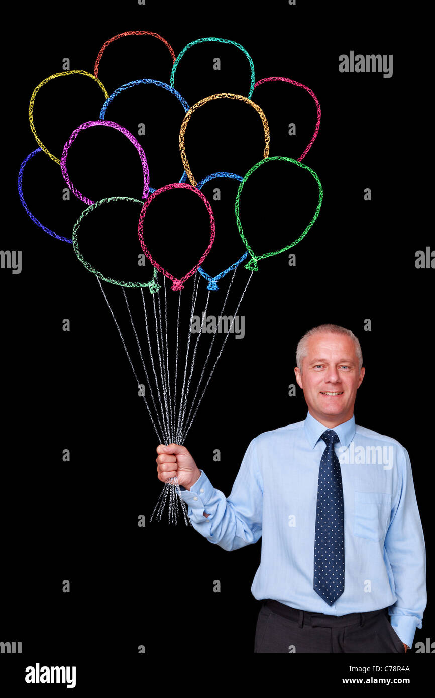 Photo d'un homme d'âge mûr sur un fond noir tenant un gros bouquet de ballons dessiné à la craie Banque D'Images