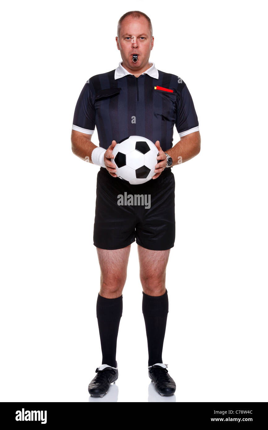 Photo pleine longueur d'un arbitre de football ou soccer tenant une balle avec un sifflet dans la bouche, isolé sur un fond blanc. Banque D'Images