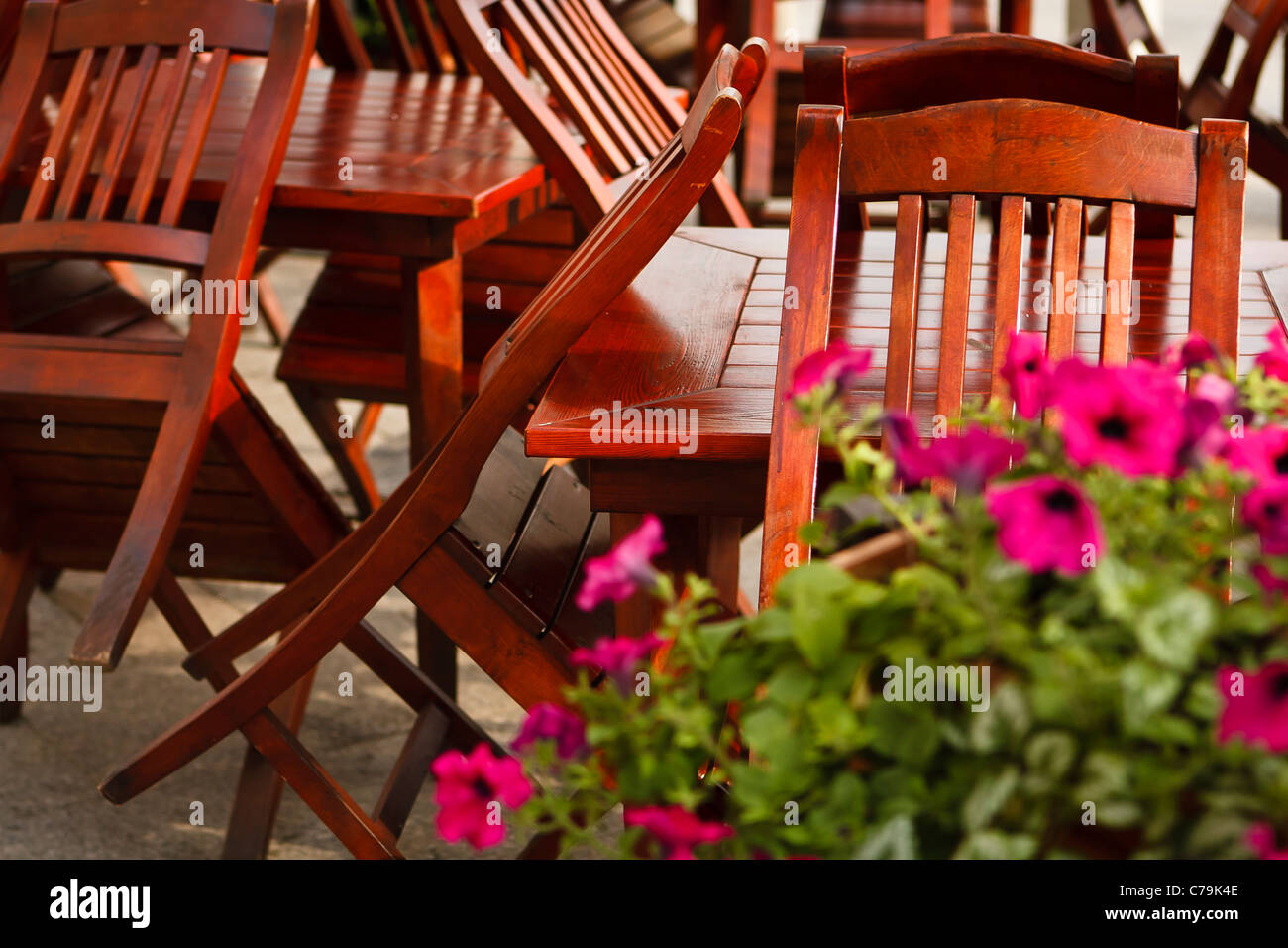 Chaises en bois pointer vers le haut contre les tables de restaurant fermé. Cracovie, Pologne. Banque D'Images