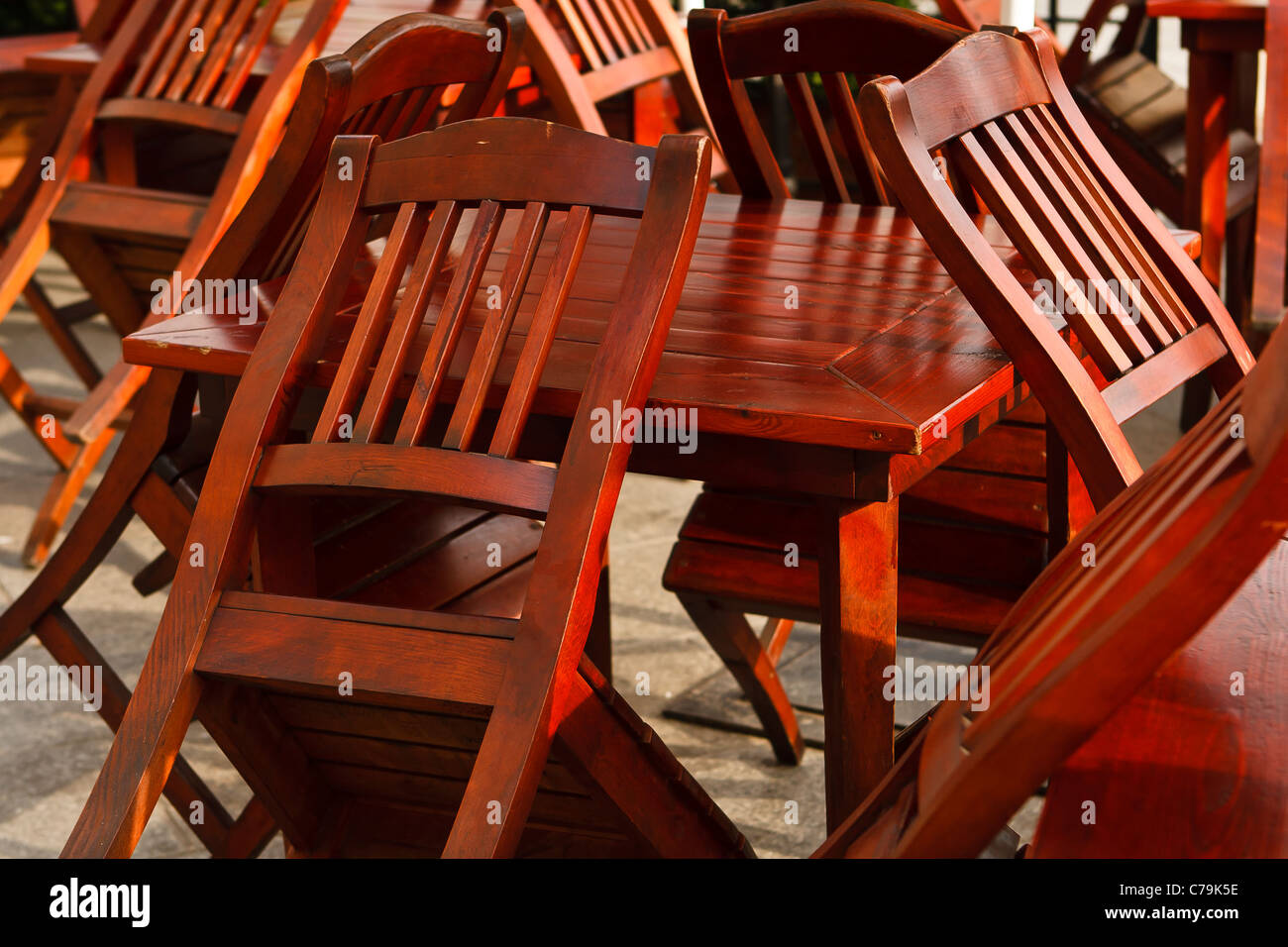 Chaises en bois pointer vers le haut contre les tables de restaurant fermé. Cracovie, Pologne. Banque D'Images